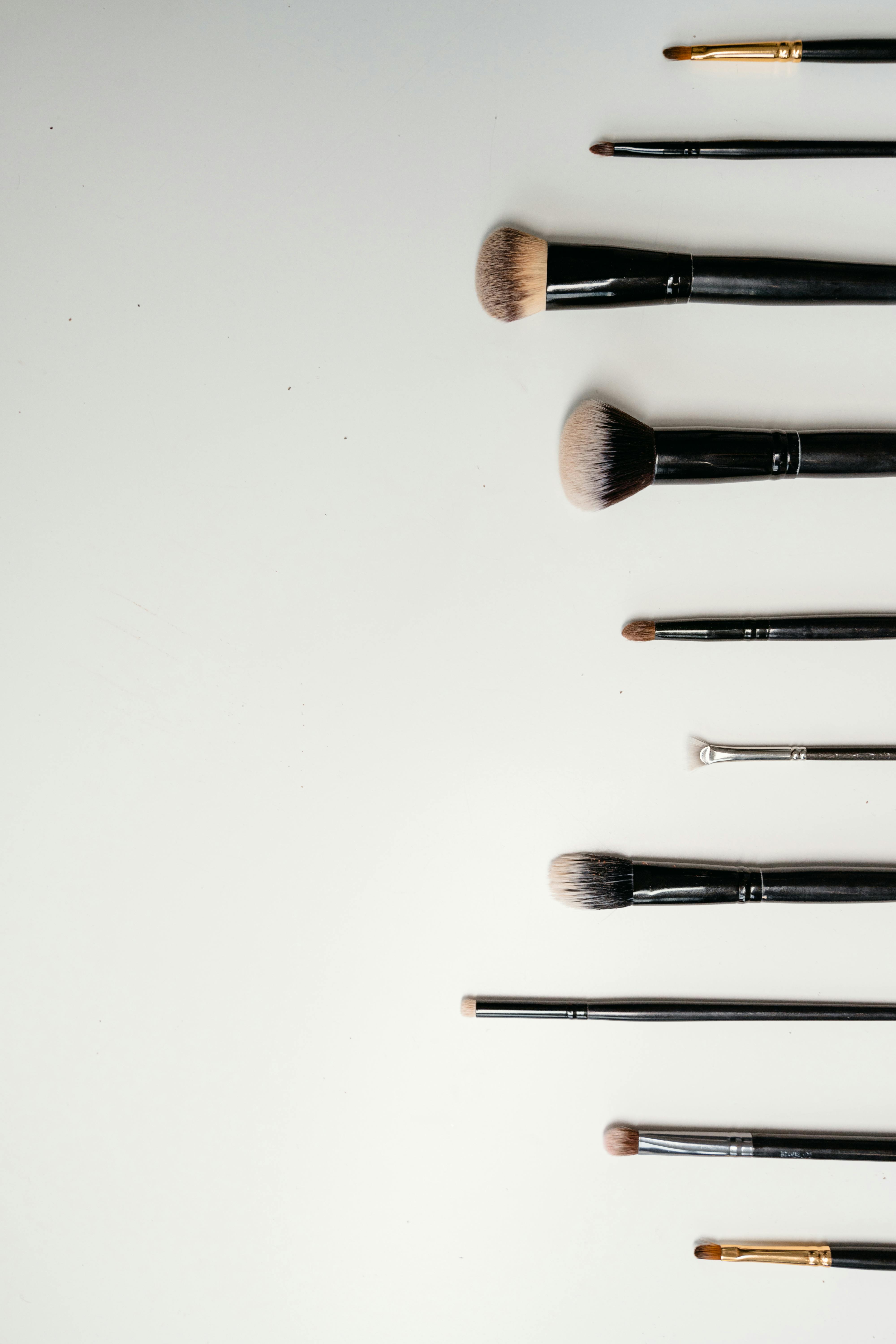 Top view flat lay of makeup brushes on a white background, ideal for beauty themes.