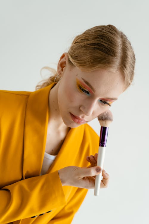 Woman in Yellow Blazer Applying Makeup