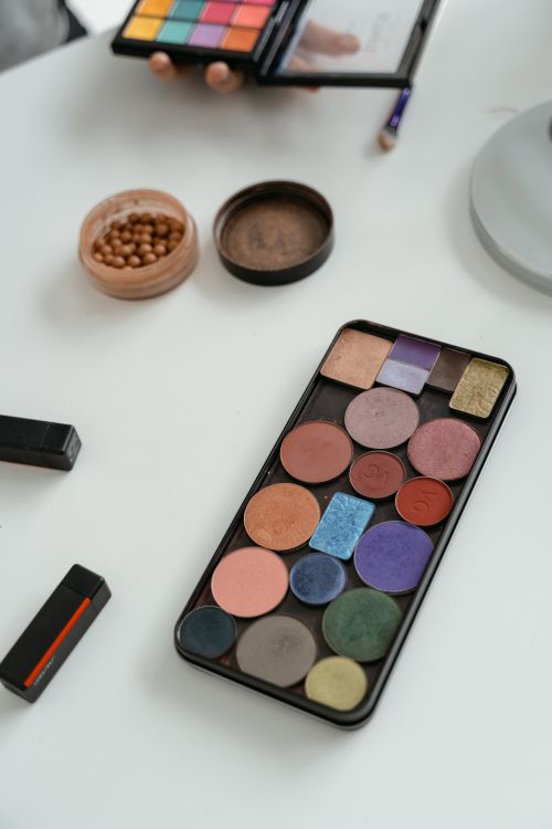Close-Up Shot of Makeup Kit on White Surface · Free Stock Photo