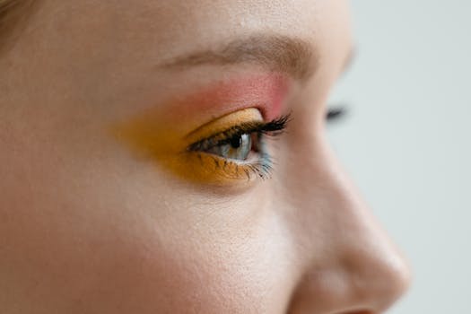 Detailed side view of an eye showcasing colorful and artistic makeup application.