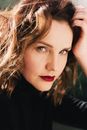 Woman with red lips and wavy hair in sunshine