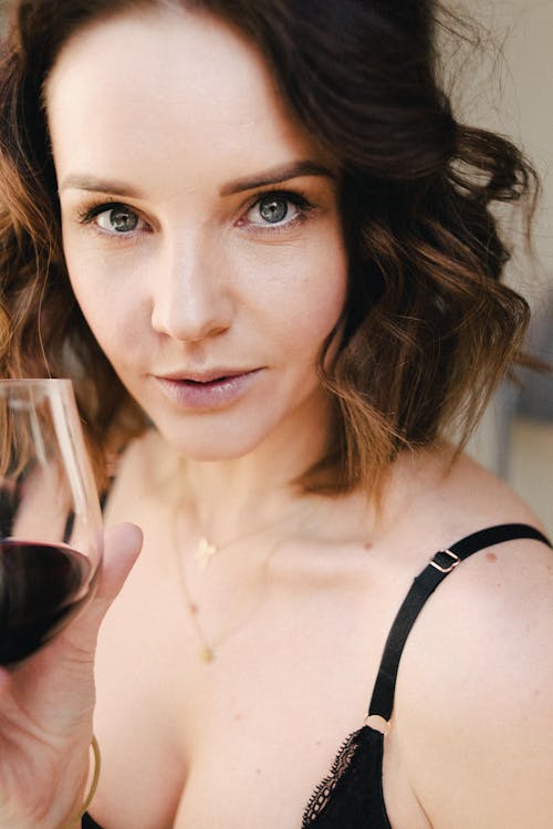 Free Crop gentle woman with red wine and gray eyes Stock Photo