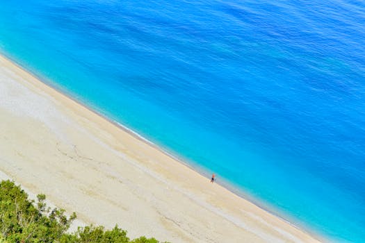 Stunning aerial view of Myrtos Beach's turquoise waters and sandy shore in Kefalonia, Greece.