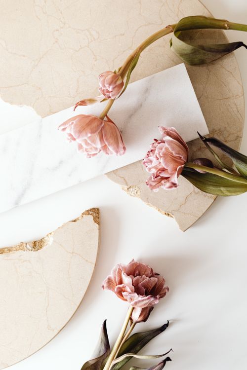 Free Delicate pink tulips artistically arranged on a marble and stone background for a sophisticated look. Stock Photo