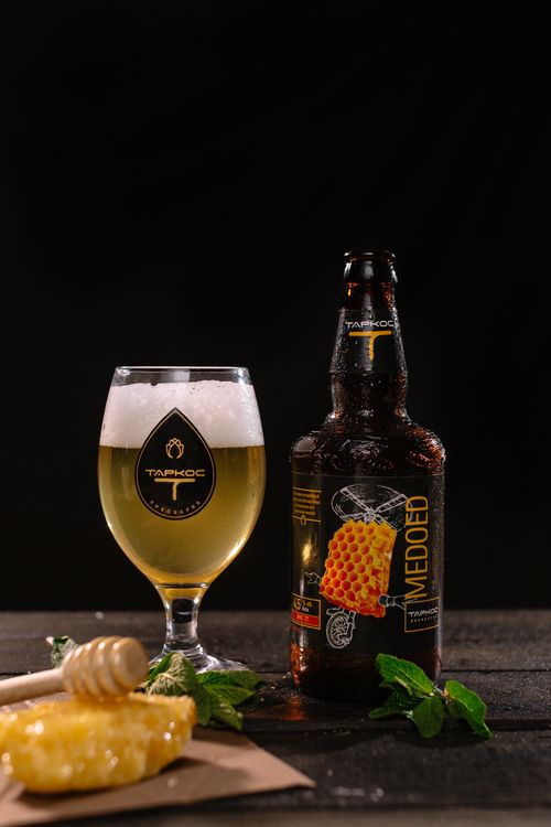 Free Close-up product shot of craft honey beer with basil leaves and honeycomb on dark background. Stock Photo