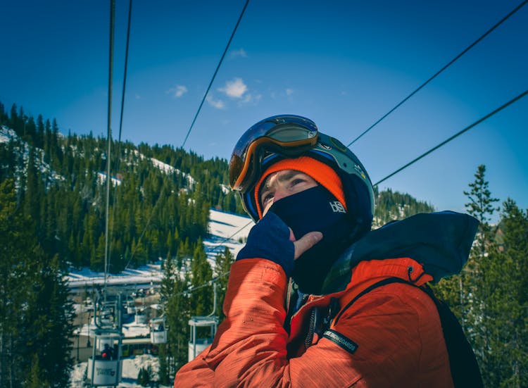 Skier Standing Under Mountain Ropeway