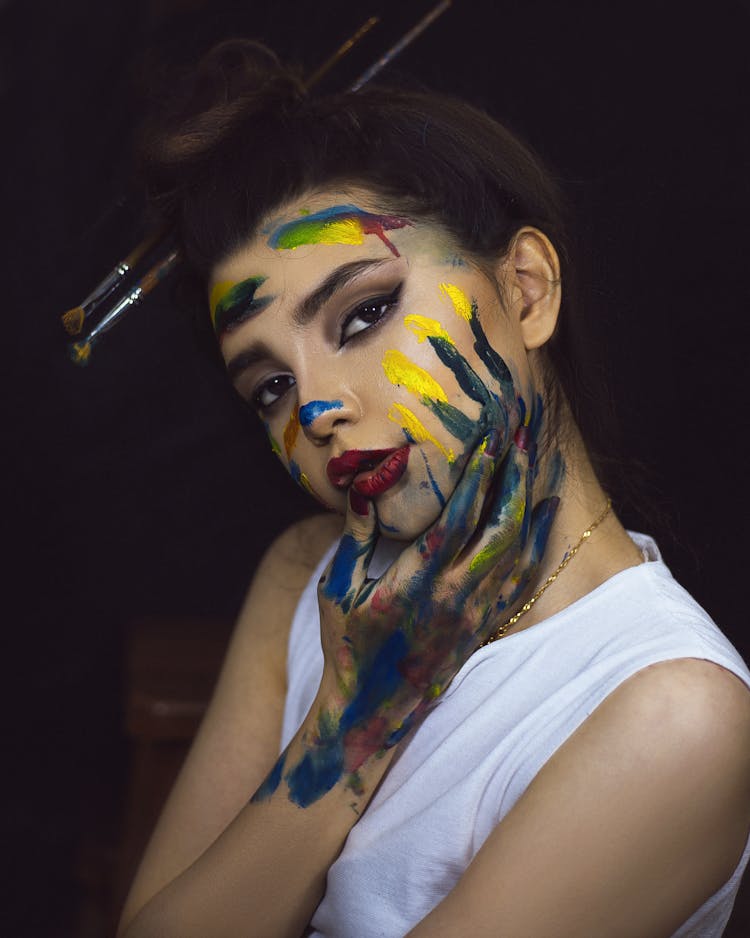 A Woman With Painting On Her Hand And Face