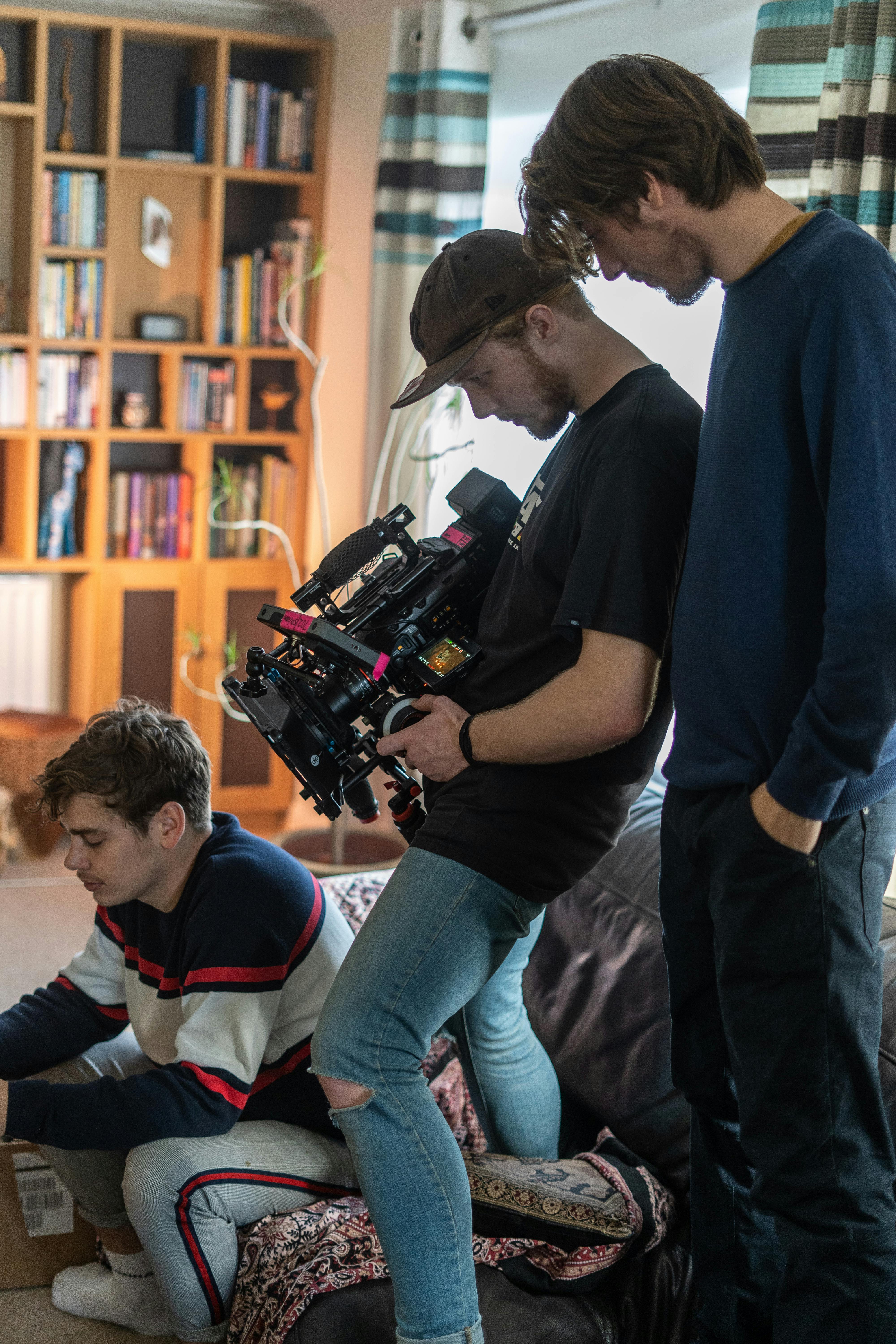 a cameraman filming an artist while sitting on the couch