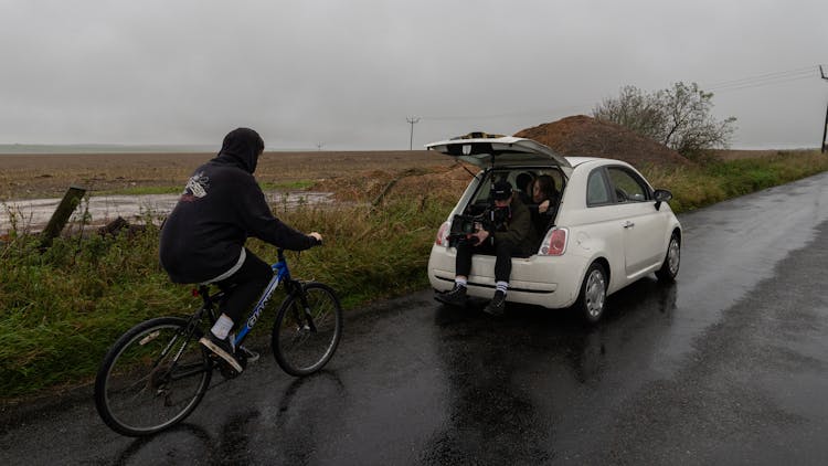 A Man Filming A Person Riding A Bike