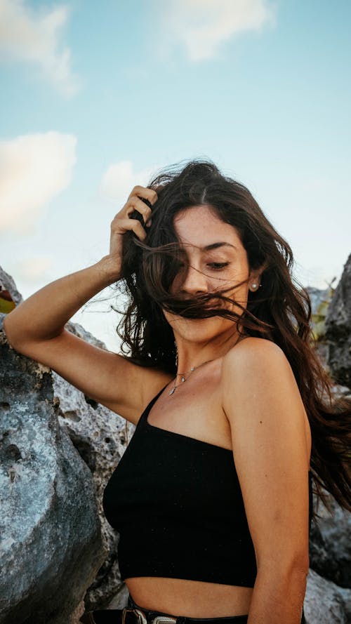 Free A Woman in Black Halter Top Holding Her Hair Stock Photo