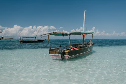 Free Boat floating in shallow water of sea Stock Photo