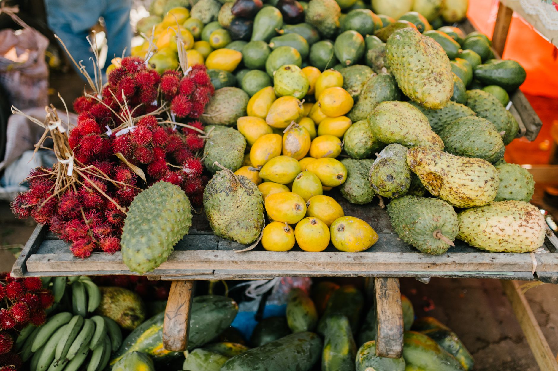 High angle of various fresh exotic fruits placed on wooden counter at local grocery store
