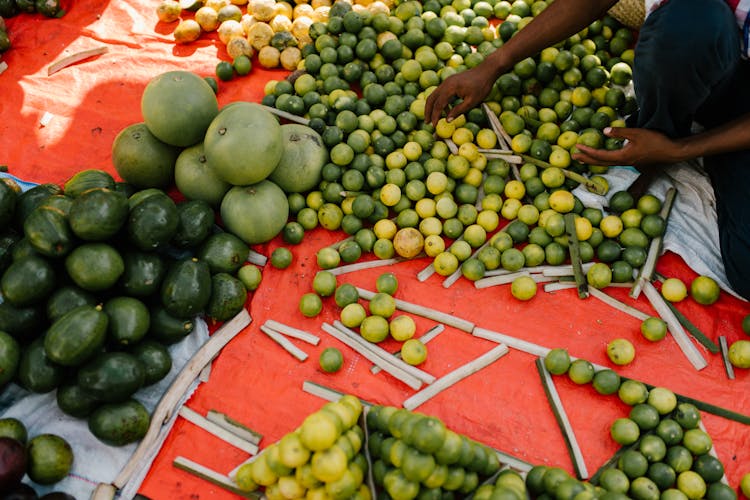 Crop Ethnic Person With Harvest Of Exotic Fruits