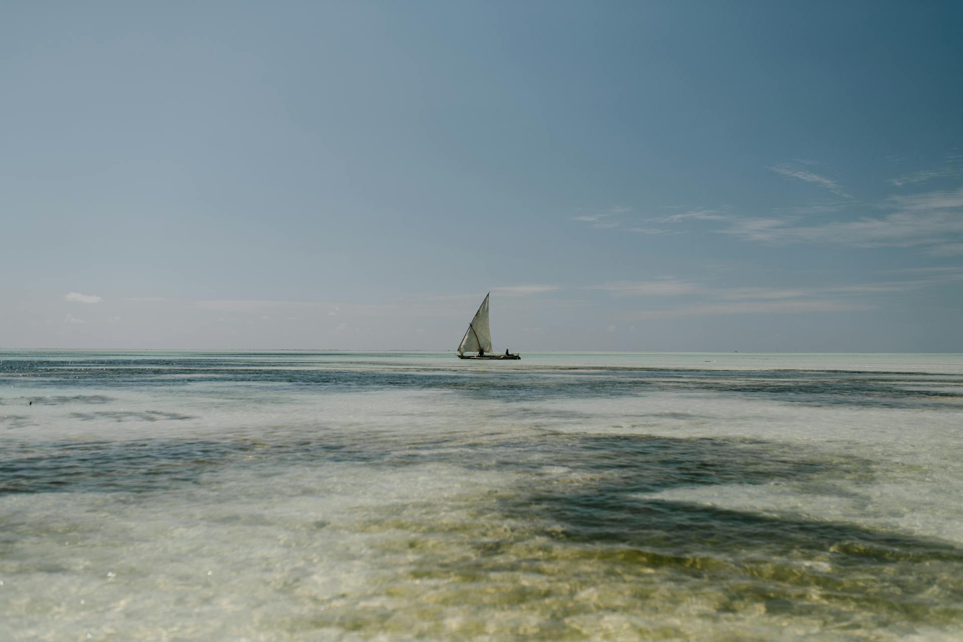 Lonely sailboat floating on foamy blue sea