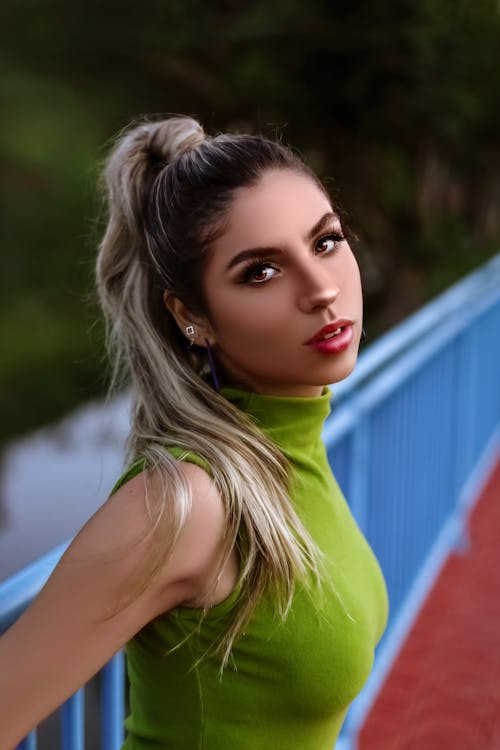 Free Trendy female standing near fence on bridge Stock Photo