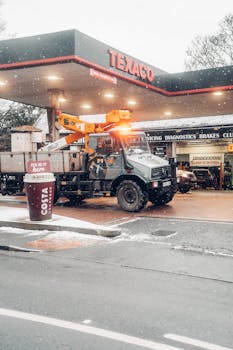 A service truck at a Texaco station during a snowy winter day in the UK. Transportation in cold weather.