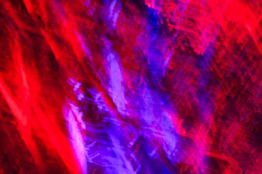 Dynamic abstract light patterns in vivid red and purple hues.