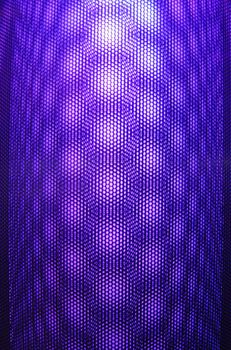 Futuristic abstract geometric pattern illuminated in violet tones creating a textured visual effect.
