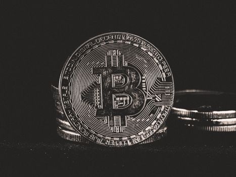 Detailed image of a silver Bitcoin coin on a dark background, highlighting cryptocurrency themes.