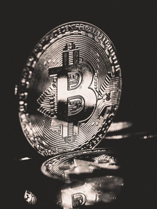Free A detailed monochrome image of a Bitcoin coin reflecting light, emphasizing cryptocurrency elegance. Stock Photo