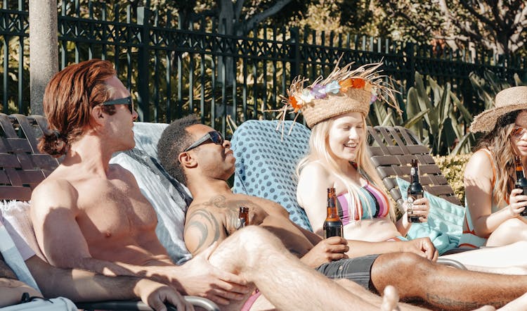 People Chilling And Relaxing While Holding Beer Bottles