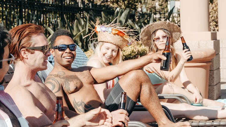 People Chilling And Relaxing While Holding Beer Bottles