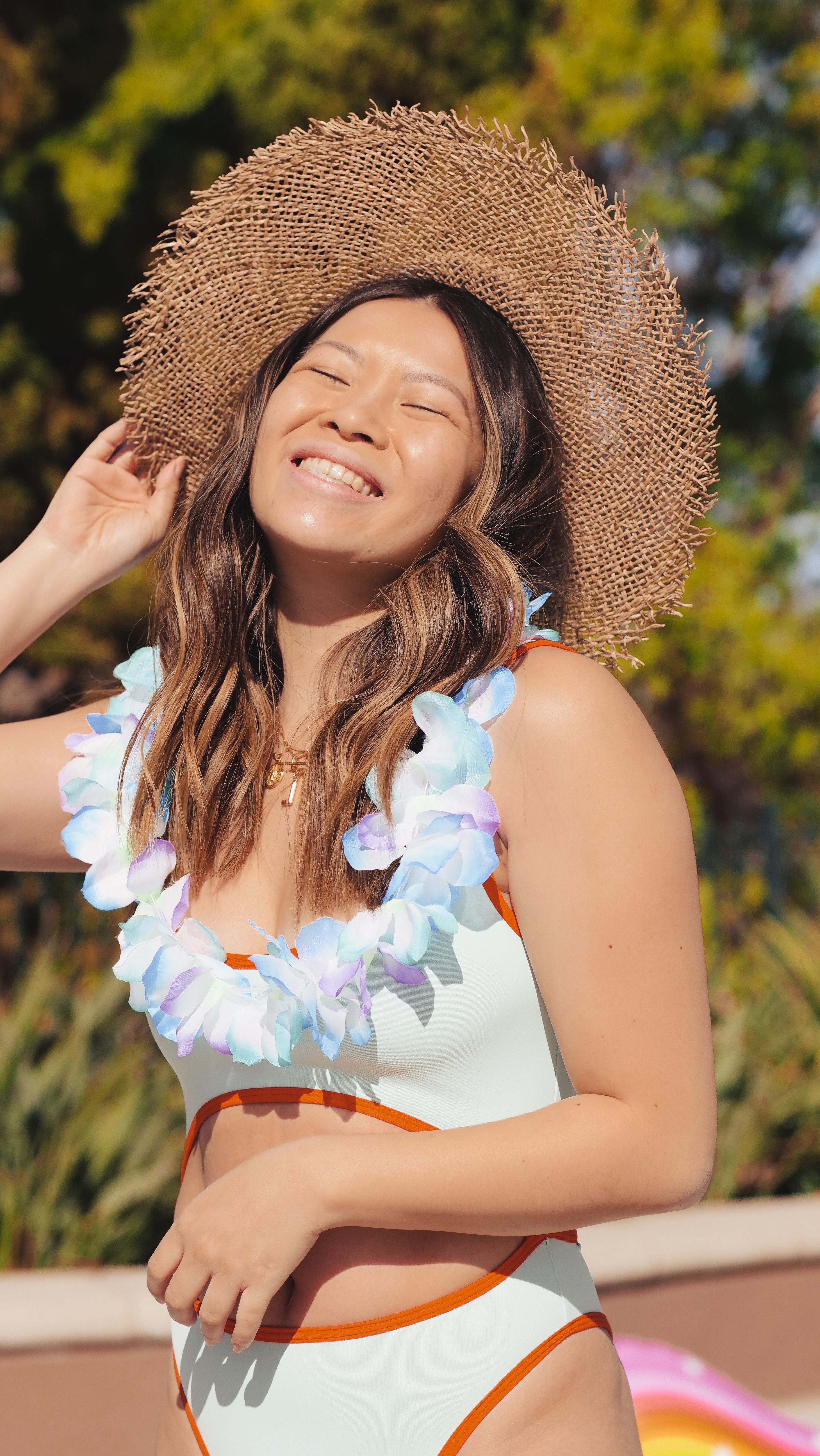 White Bathing Suit Holding a Straw Hat 