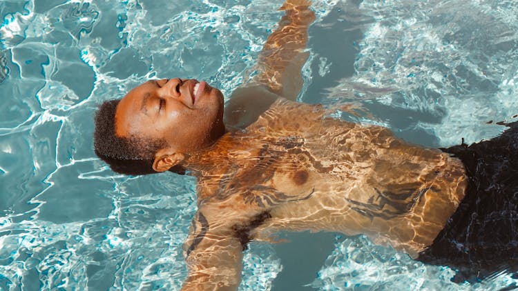 Man Relaxing In The Swimming Pool