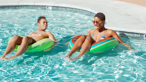 Free Man and Woman Smiling in the Swimming Pool Stock Photo