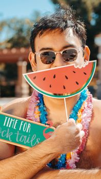 Man enjoying a lively summer pool party with fun props, sunglasses, and leis.
