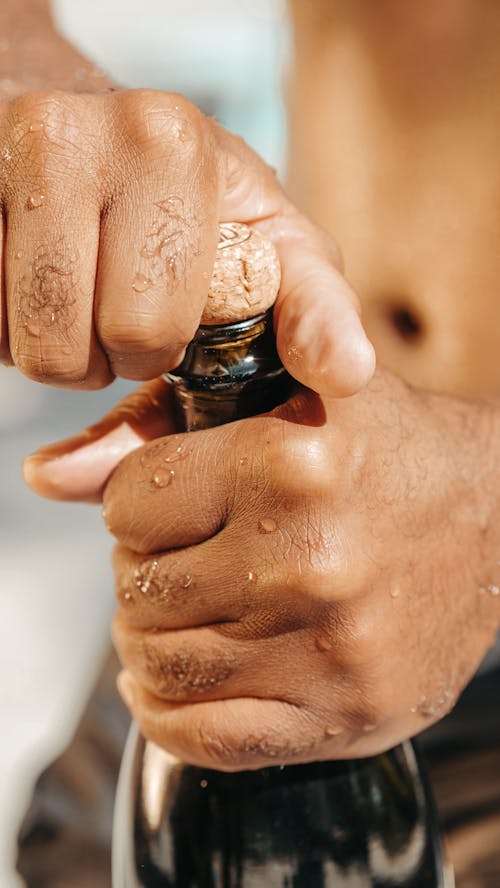 Close-Up Photo of Person Opening a Champagne Bottle