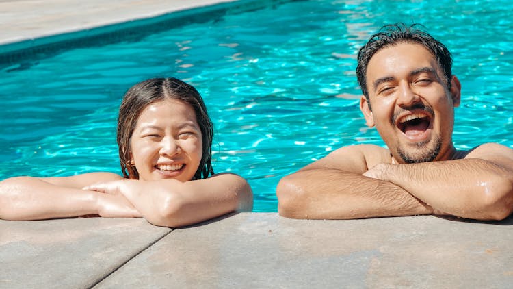 Woman And Man Smiling In The Swimming Pool