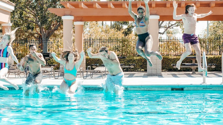 People Plunging Into The Pool