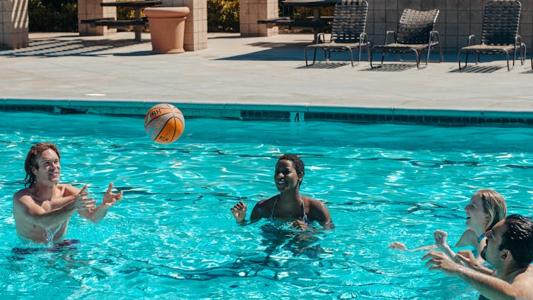 People Having Fun Playing Basketball In The Swimming Pool