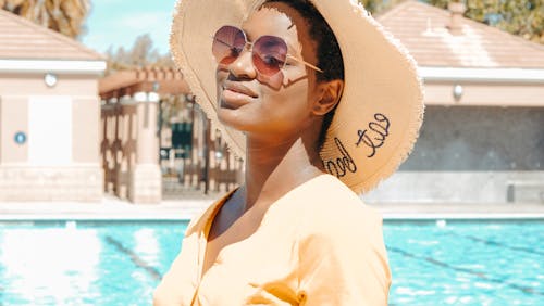 Woman Smiling while Wearing Sunglasses and Sun Hat