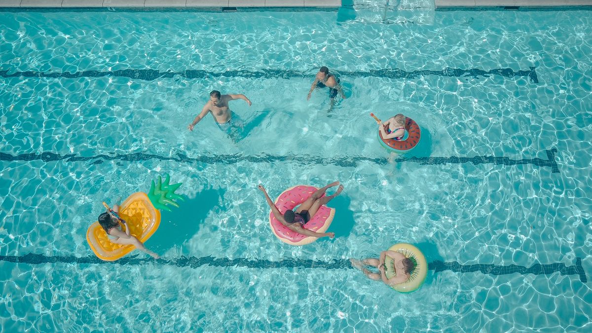21st birthday party ideas with friends enjoying pool party games with colorful floats in a swimming pool