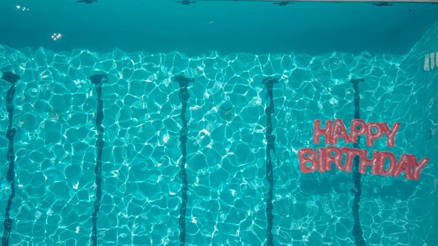 Top view of a swimming pool with a 'Happy Birthday' message, perfect for festive occasions.