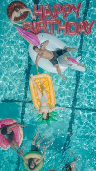 Enjoying a summer pool party with colorful floats and birthday vibes.