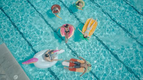 Free A vibrant aerial view of friends enjoying a pool party with fun floaties. Stock Photo
