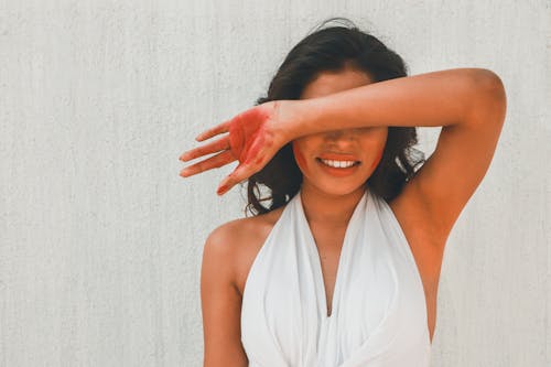 Free Woman in White Halter Top Covering Eyes with Arm Stock Photo