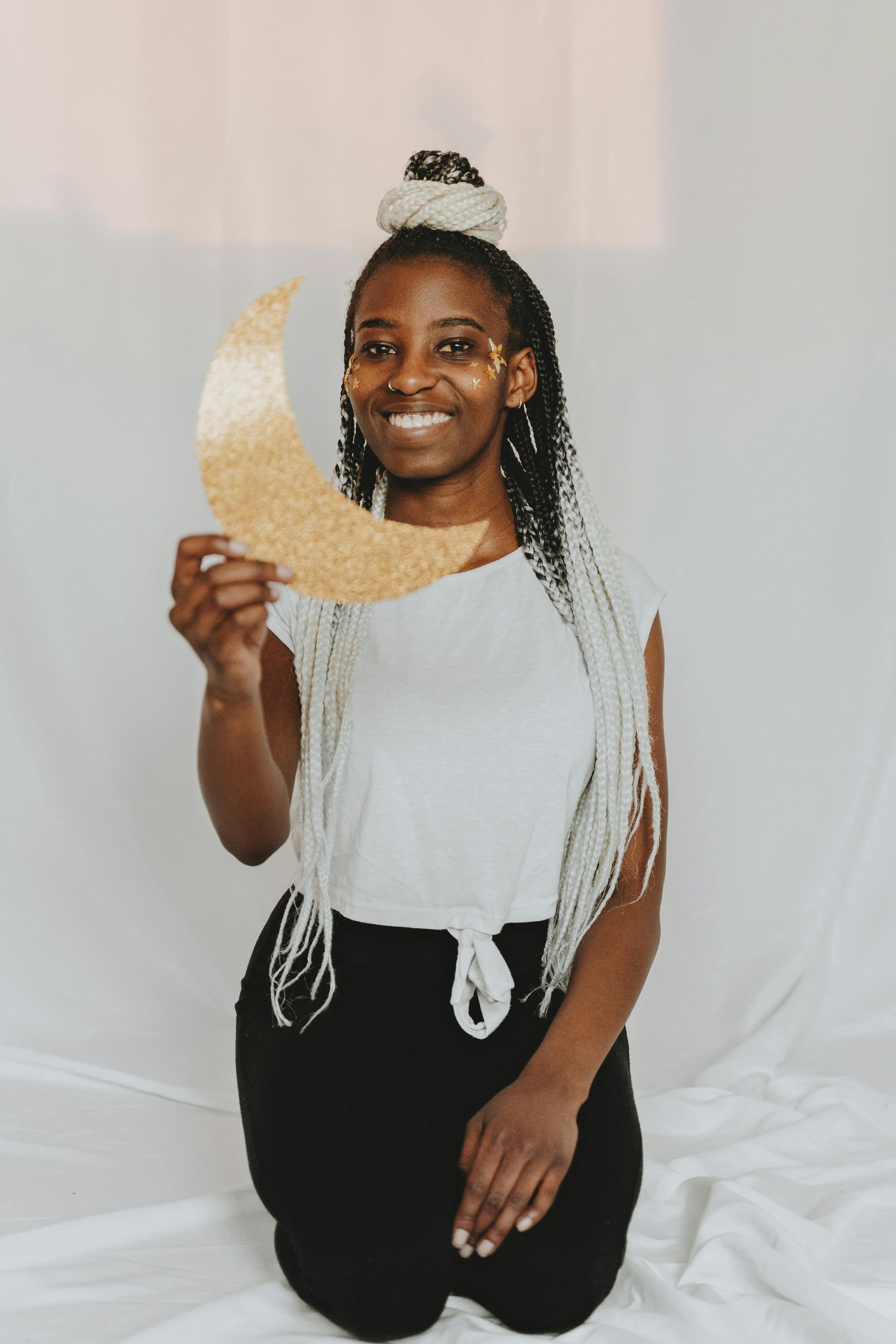 woman holding gold half moon paper cutouts