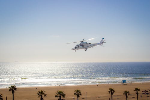 White and Blue Airplane Flying over the Sea