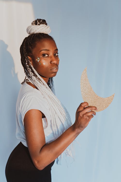 Woman with White Hair Extensions Holding Gold Half Moon Cut Out