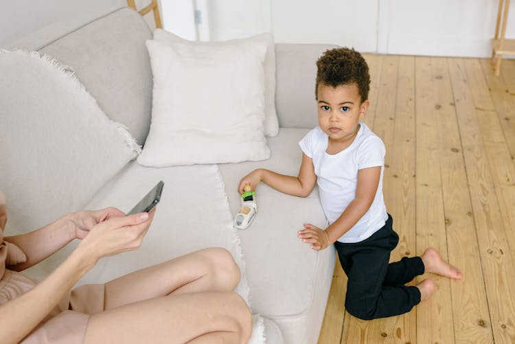 Boy In White Shirt Kneeling On Wooden Floor