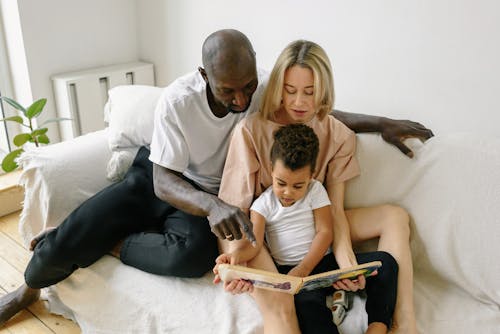 Interracial Couple Reading Book to Child