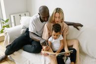 Interracial Couple Reading Book to Child
