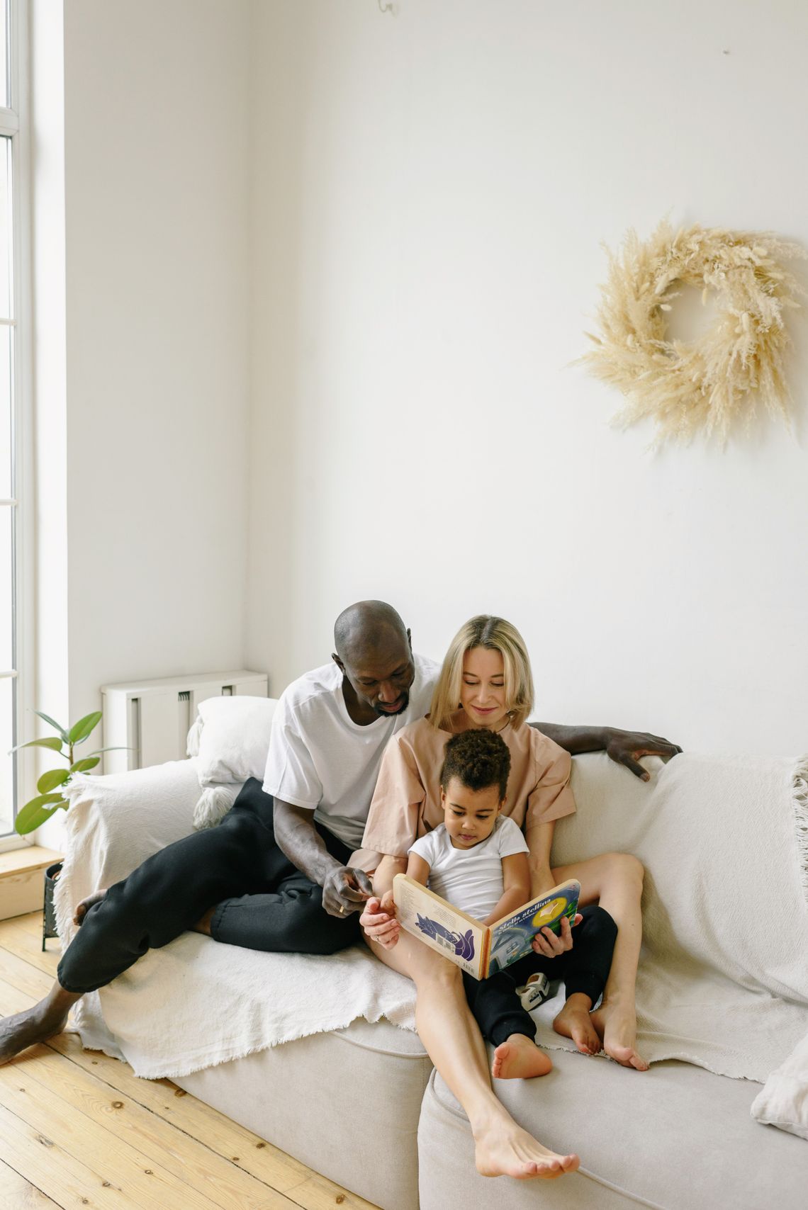 Family enjoying story time together on a comfortable sofa at home