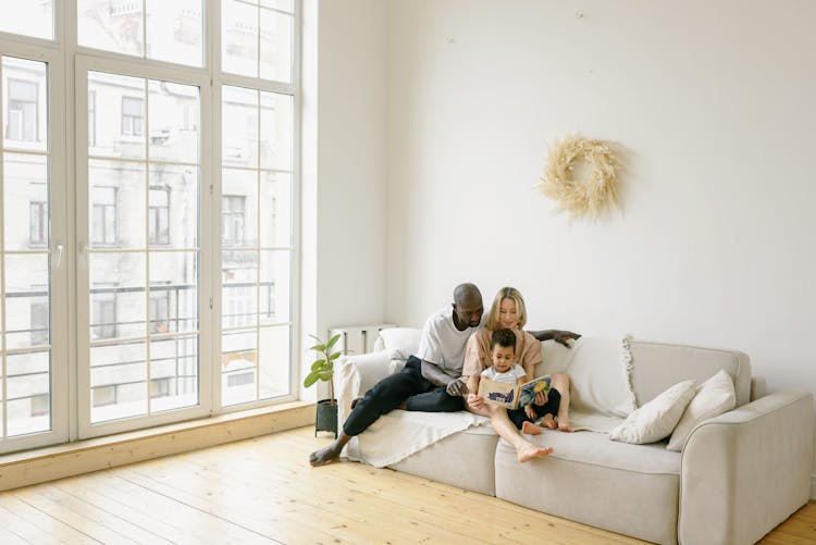 Multiracial Family Sitting On Gray Couch