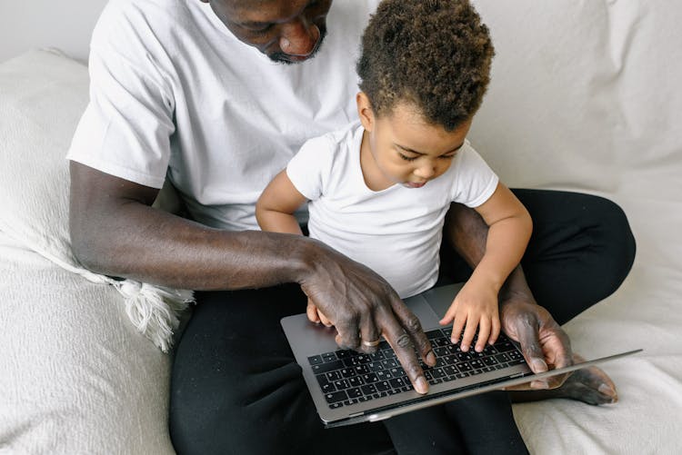 Father And Child Typing On Laptop