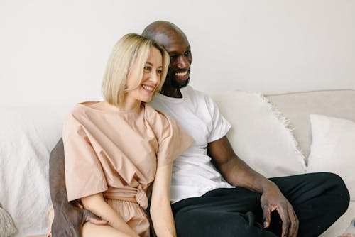 A Smiling Couple Sitting on the Couch Together